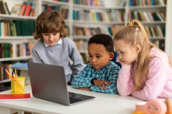 Diverse students using tablets in a classroom